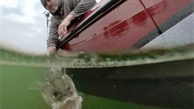 Man pulling fish from water.